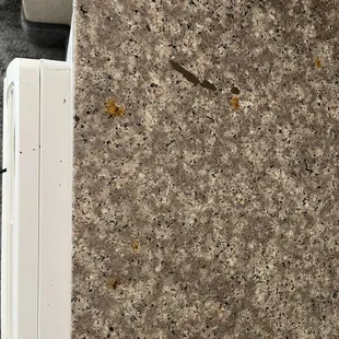 Dirty counter, food and ash on the counter and AC unit.