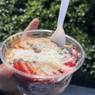 Acai with granola, almond butter, coconut shreds, chia seeds, strawberries, and condensed milk drizzle.