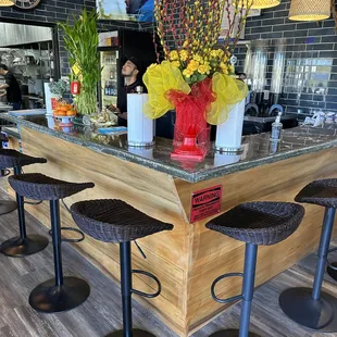 a bar with stools and flowers