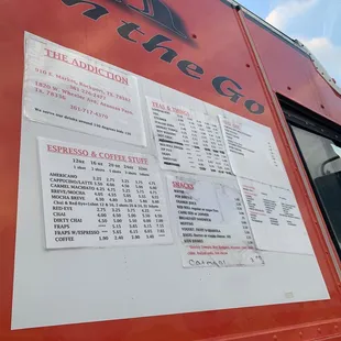a red food truck with a menu on the side