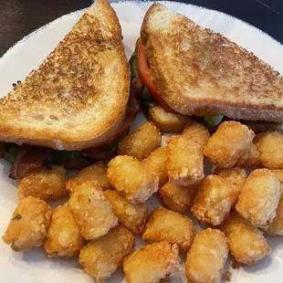 BLTA- Bacon Lettuce Tomato and Avocado sandwich with tater tots.
