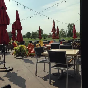 a patio with tables and chairs and umbrellas