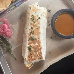 Carne asada burrito with a blistered jalapeño and pickled onions