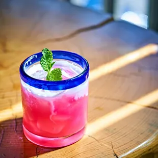 a pink drink in a blue glass