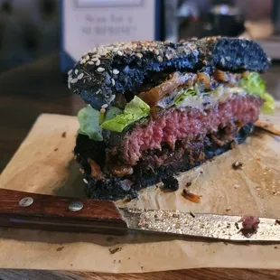 The Wagyu Burger topped w/white cheddar, caramelized onions &amp; tomato jam(lettuce), w/apple slaw on black focaccia