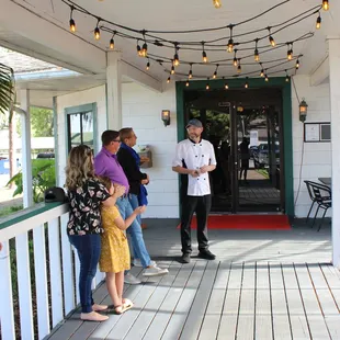 a chef standing on a porch