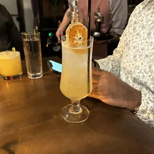 a man sitting at a table with a drink