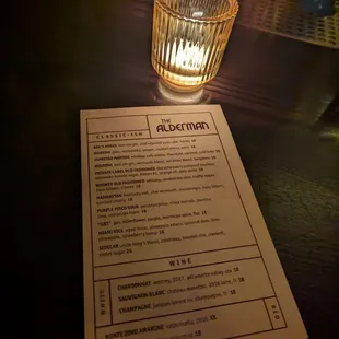 a menu and a candle on a table