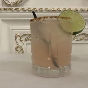 a cocktail with a lime slice on the rim