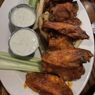 a plate of chicken wings and celery sticks