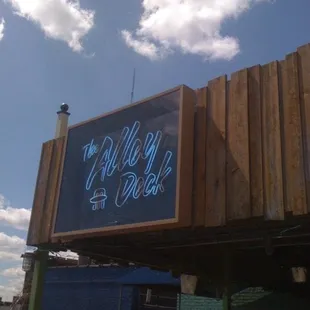 the neon sign for the alley deck