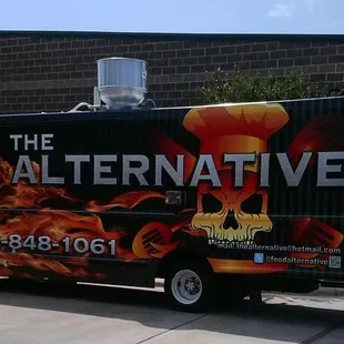 a black food truck with flames on it