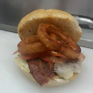 a bacon, cheese, and onion rings sandwich