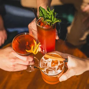 a group of people toasting with cocktails