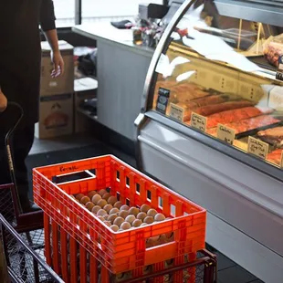 a man standing in front of a case of meat