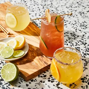 a variety of cocktails on a cutting board