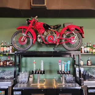 a motorcycle on a shelf above a bar
