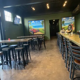 a long bar with stools and tables
