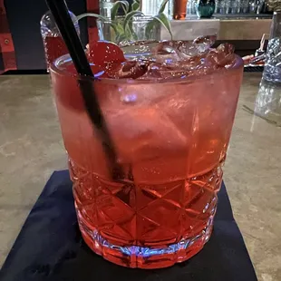 a red drink with ice and a straw