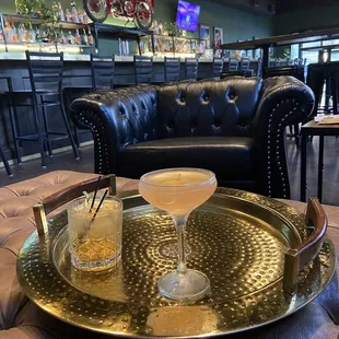 two cocktails on a gold tray