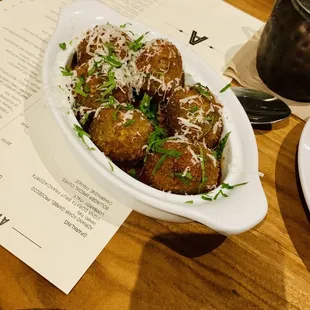 a plate of meatballs with parmesan cheese
