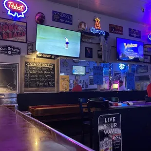 a bar with neon signs on the wall