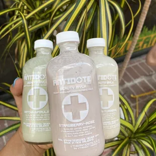 a hand holding three bottles