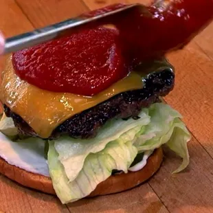 a person cutting a hamburger with a knife
