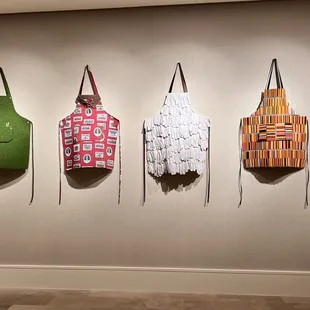 a row of aprons hanging on a wall
