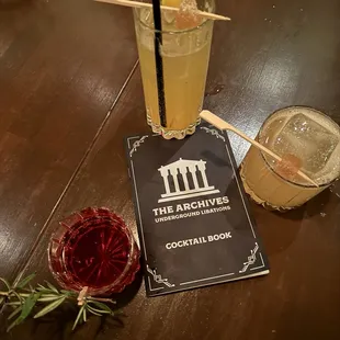 a cocktail and a book on a table