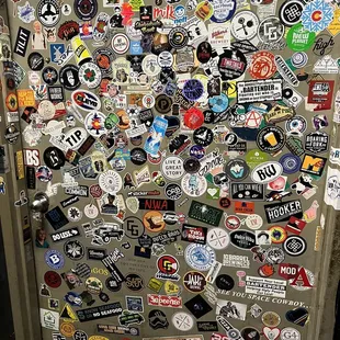 a refrigerator covered in stickers