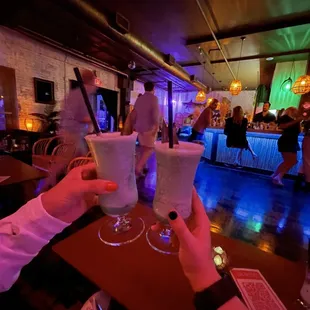 two people toasting at a bar