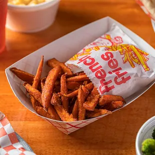 a hot dog, fries, and broccoli