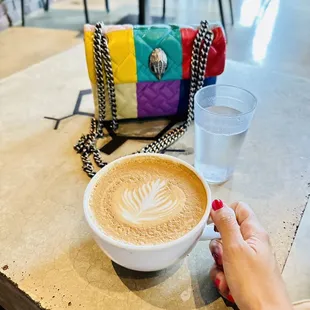 a woman&apos;s hand holding a cup of coffee