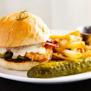 a chicken sandwich and pickle on a plate