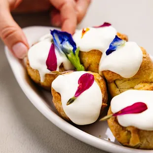 a person holding a plate of pastries