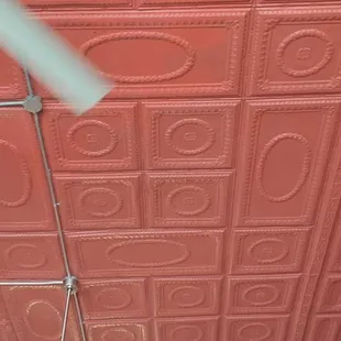 a man in a red room with a ceiling fan