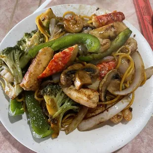 Noodles, broccoli, mushrooms, onions, green peppers, cabbage, shrimp, and crab.