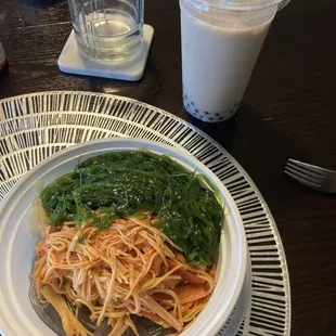 a plate of noodles and spinach