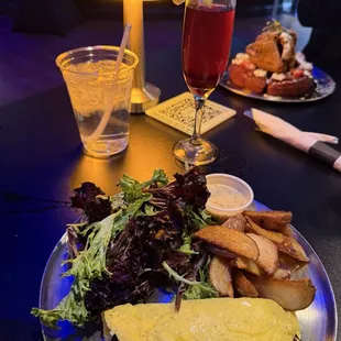 Toad&apos;s Omelet with Ginger Huckleberry Mimosa and in the back Chicken and waffle