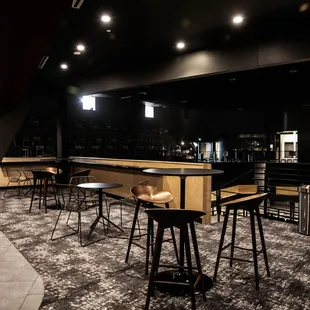 a bar with stools and tables