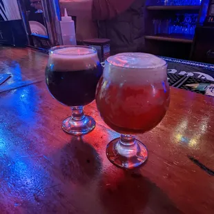 two glasses of beer on a bar