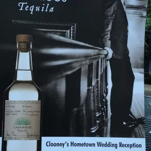 a man standing next to a bottle of liquor