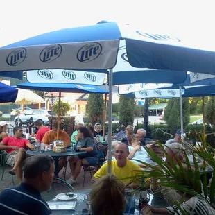 a group of people sitting under umbrellas