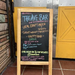 a chalkboard sign outside of a bar