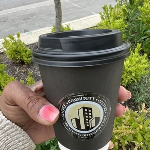a hand holding a coffee cup