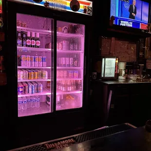 a neon display of beer and sodas