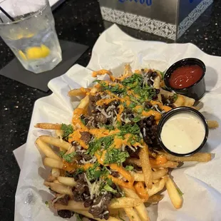 a plate of fries with cheese and ketchup