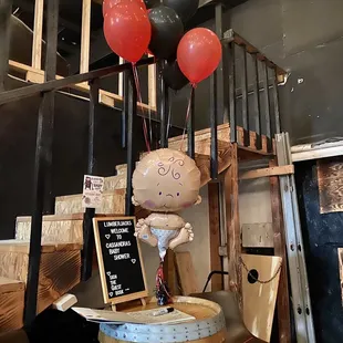 a table with balloons and a sign