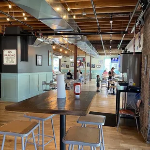  a dining area with tables and stools
